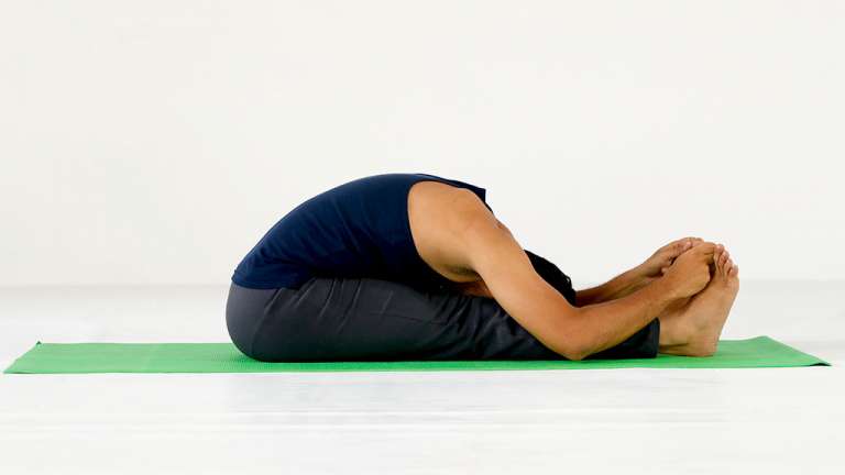 Woman practicing seated forward bend asana in yoga studio. Paschimottanasana  pose | Yoga studio, Asana, Poses