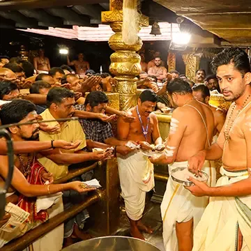 Priests distributing the holy ash after the pooja in front of the sreekovil at Sabarimala